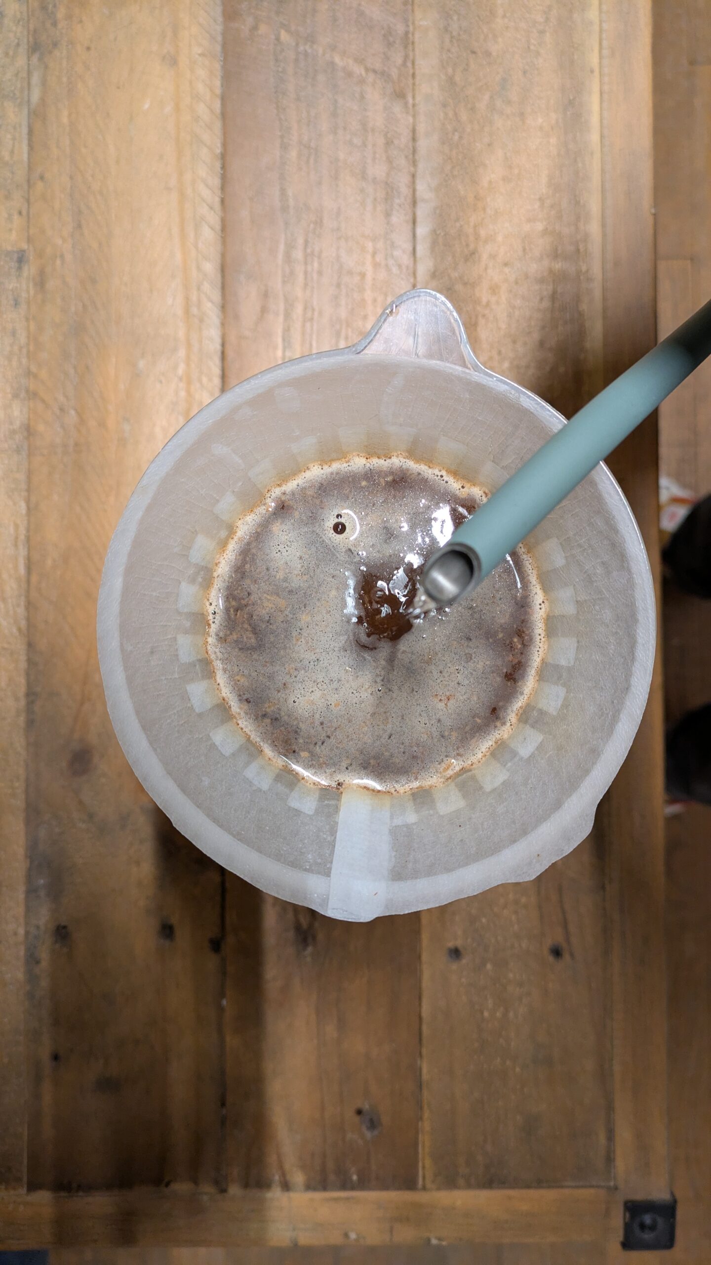 Overhead view of a coffee filter with brewing coffee and hot water being poured at a Uppsala Workshop.